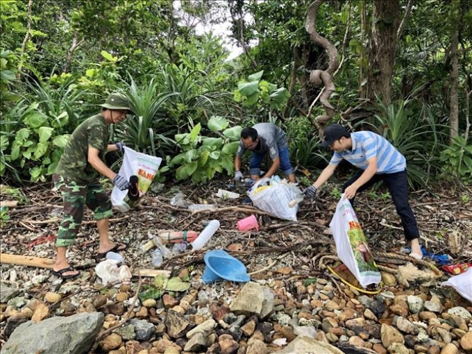 Người dân Côn Đảo thu nhặt và phân loại rác tại bãi biển ông Câu. Ảnh: TTXVN phát