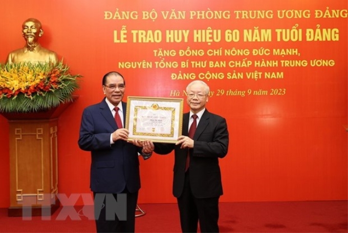 Tổng Bí thư Nguyễn Phú Trọng trao Huy hiệu 60 năm tuổi Đảng cho nguyên Tổng Bí thư Nông Đức Mạnh. (Ảnh: Trí Dũng/TTXVN)