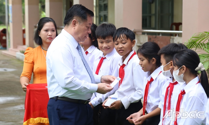 Đồng chí Nguyễn Trọng Nghĩa tặng quà cho học sinh Trường THCS Tân Phú.