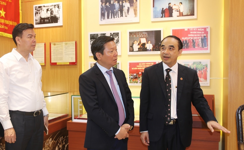GS. TS. Nguyễn Hữu Tú, Hiệu trưởng Trường Đại học Y Hà Nội giới thiệu với đồng chí Trần Thanh Lâm những hiện vật trưng bày tại Phòng Truyền thống.