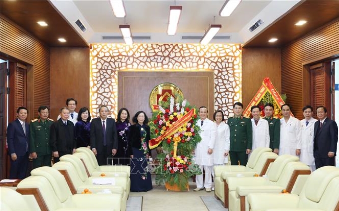 Thường trực Ban Bí thư Trương Thị Mai tặng hoa chúc mừng các thầy thuốc Bệnh Trung ương Quân đội 108. (Ảnh: TTXVN)