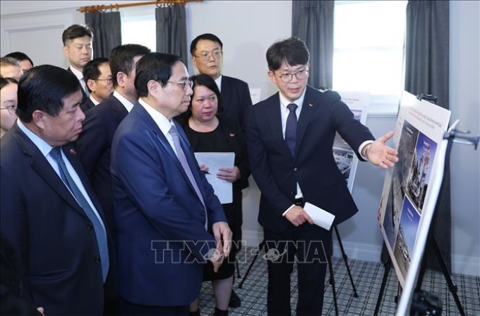 Lãnh đạo Tập đoàn SK (Hàn Quốc) giới thiệu với Thủ tướng Phạm Minh Chính các dự án của tập đoàn tại Australia. (Ảnh: TTXVN)