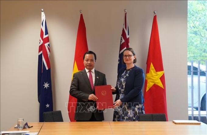 Thứ trưởng Bộ Tư pháp Việt Nam Trần Tiến Dũng và Thứ trưởng Bộ Tư pháp Australia Tara Inverarity trao Ý định thư hợp tác giữa hai Bộ. Ảnh: Lê Đạt/TTXVN