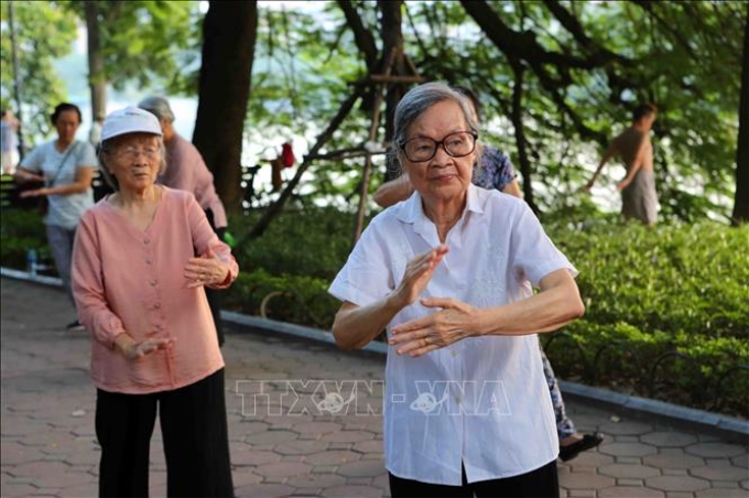 Người cao tuổi tập thể dục dưỡng sinh tại khu vực hồ Hoàn Kiếm - Hà Nội. (Ảnh: TTXVN)