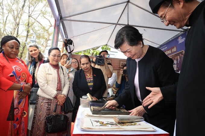 Các nữ đại sứ, trưởng đại diện các tổ chức quốc tế tại Việt Nam trải nghiệm làm tranh Đông Hồ tại làng Đồng Kỵ, thành phố Từ Sơn, tỉnh Bắc Ninh. (Ảnh: TTXVN)