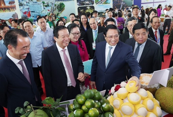 Ủy viên Bộ Chính trị, Thủ tướng Chính phủ Phạm Minh Chính tham quan gian trưng bày, giới thiệu sản phẩm nông nghiệp của tỉnh Vĩnh Long. (Ảnh: TTXVN)