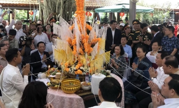 Đồng chí Trương Thị Mai và các đại biểu thực hiện nghi lễ truyền thống của Lào. (Ảnh: TTXVN)