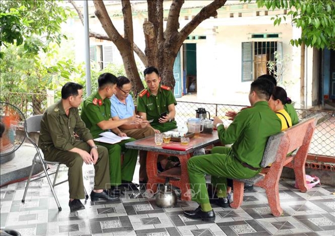 Cán bộ, chiến sĩ Công an xã An Sinh, thị xã Đông Triều, Quảng Ninh giúp đỡ người dân cài đặt định danh điện tử, sử dụng căn cước công dân gắn chíp. (Ảnh minh họa: TTXVN)