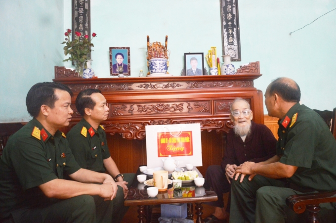 Chính ủy Bộ CHQS tỉnh Hoàng Nam Chung cùng các đồng chí trong đoàn lắng nghe tâm sự của cựu chiến sĩ Điện Biên. (Ảnh: baovinhphuc.com.vn)
