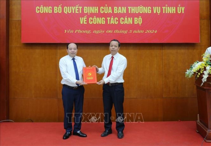 Phó Bí thư Thường trực Tỉnh ủy, Chủ tịch HĐND tỉnh Bắc Ninh Nguyễn Quốc Chung (phải) trao Quyết định cho tân Bí thư Huyện ủy Yên Phong Hoàng Bá Huy.