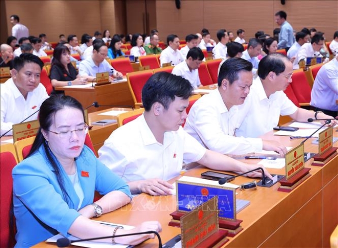Đại biểu biểu quyết về việc tán thành chủ trương sắp xếp đơn vị hành chính cấp huyện, cấp xã giai đoạn 2023-2025 của thành phố Hà Nội. (Ảnh: TTXVN)