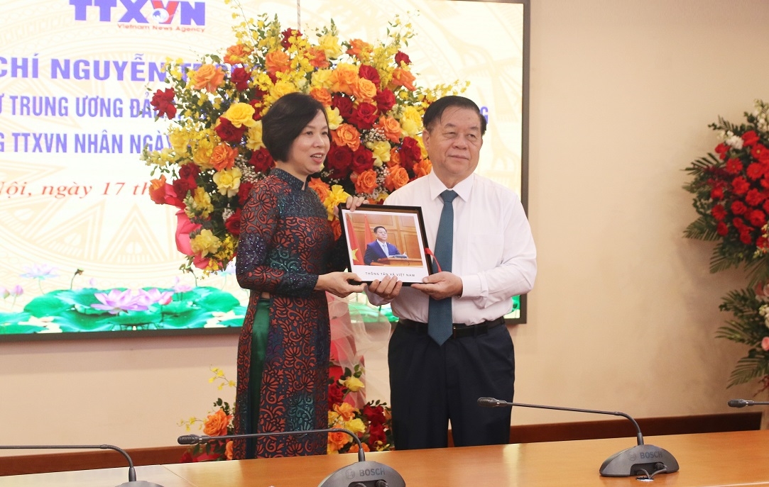 Tổng Giám đốc TTXVN Vũ Việt Trang trao tặng đồng chí Nguyễn Trọng Nghĩa cuốn sách ảnh.