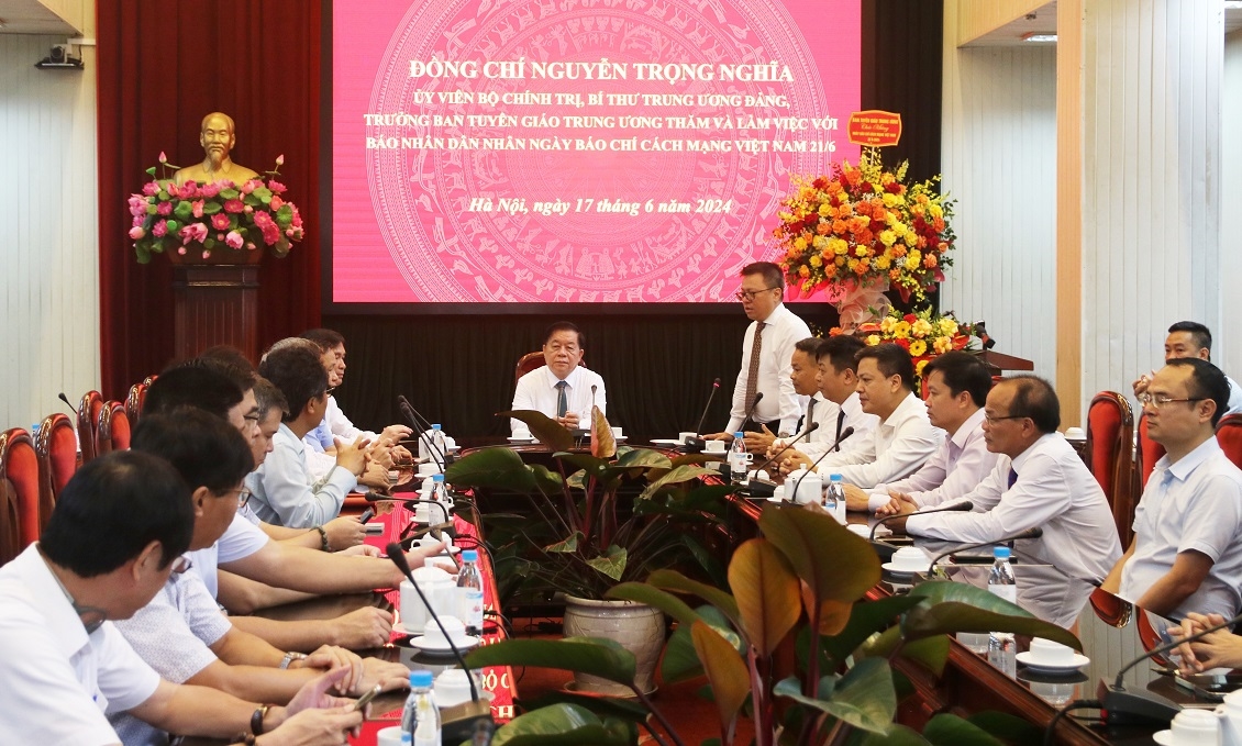 Đồng chí Nguyễn Trọng Nghĩa và các đại biểu nghe Tổng Biên tập Báo Nhân Dân báo cáo một số kết quả nổi bật trong đổi mới, nâng cao chất lượng của Báo Nhân Dân.
