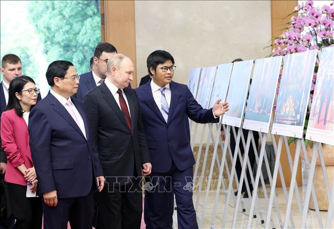 Thủ tướng Phạm Minh Chính và Tổng thống Liên bang Nga Vladimir Putin xem trưng bày ảnh về quan hệ Việt - Nga. Ảnh: Dương Giang/TTXVN