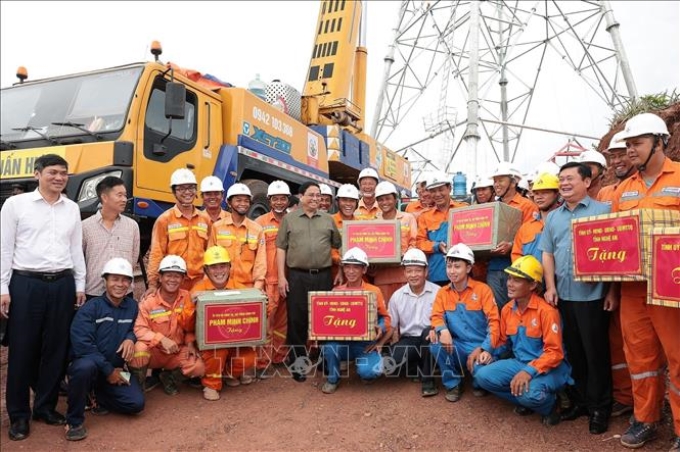 Thủ tướng Phạm Minh Chính tặng quà kỹ sư, công nhân các đơn vị đang thi công dự án đường dây tải điện 500kV mạch 3 Quảng Trạch - Phố Nối đoạn qua tỉnh Nghệ An. (Ảnh: TTXVN)