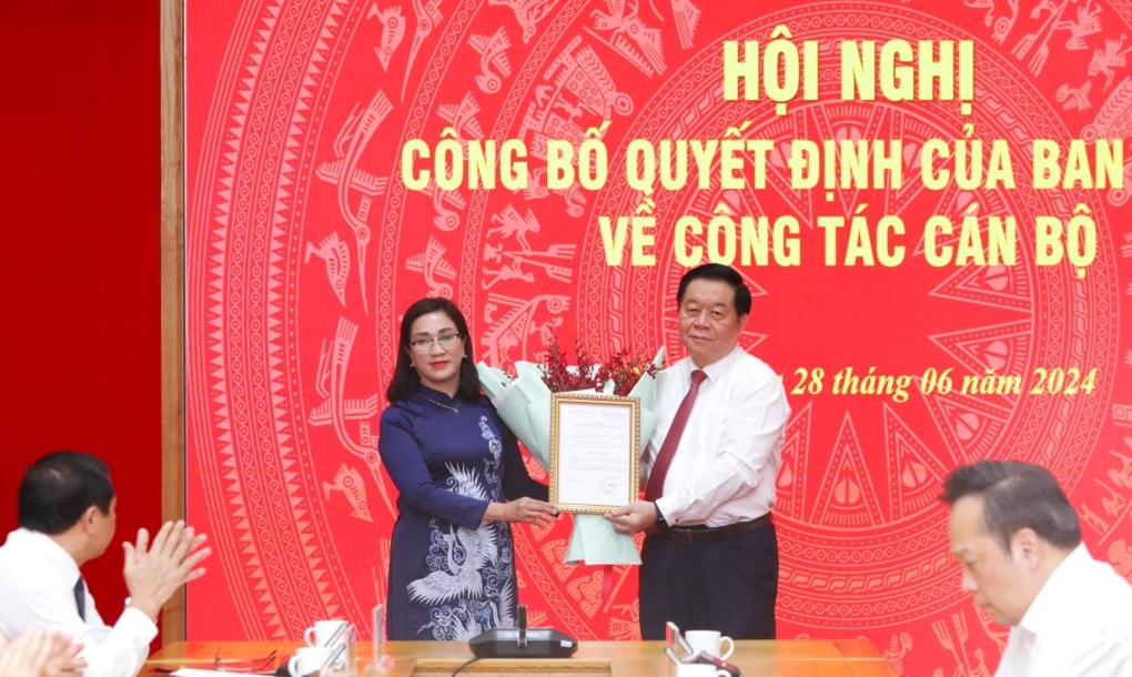 Đồng chí Nguyễn Trọng Nghĩa, Ủy viên Bộ Chính trị, Bí thư Trung ương Đảng, Trưởng Ban Tuyên giáo Trung ương trao Quyết định và tặng hoa chúc mừng đồng chí Đinh Thị Mai.