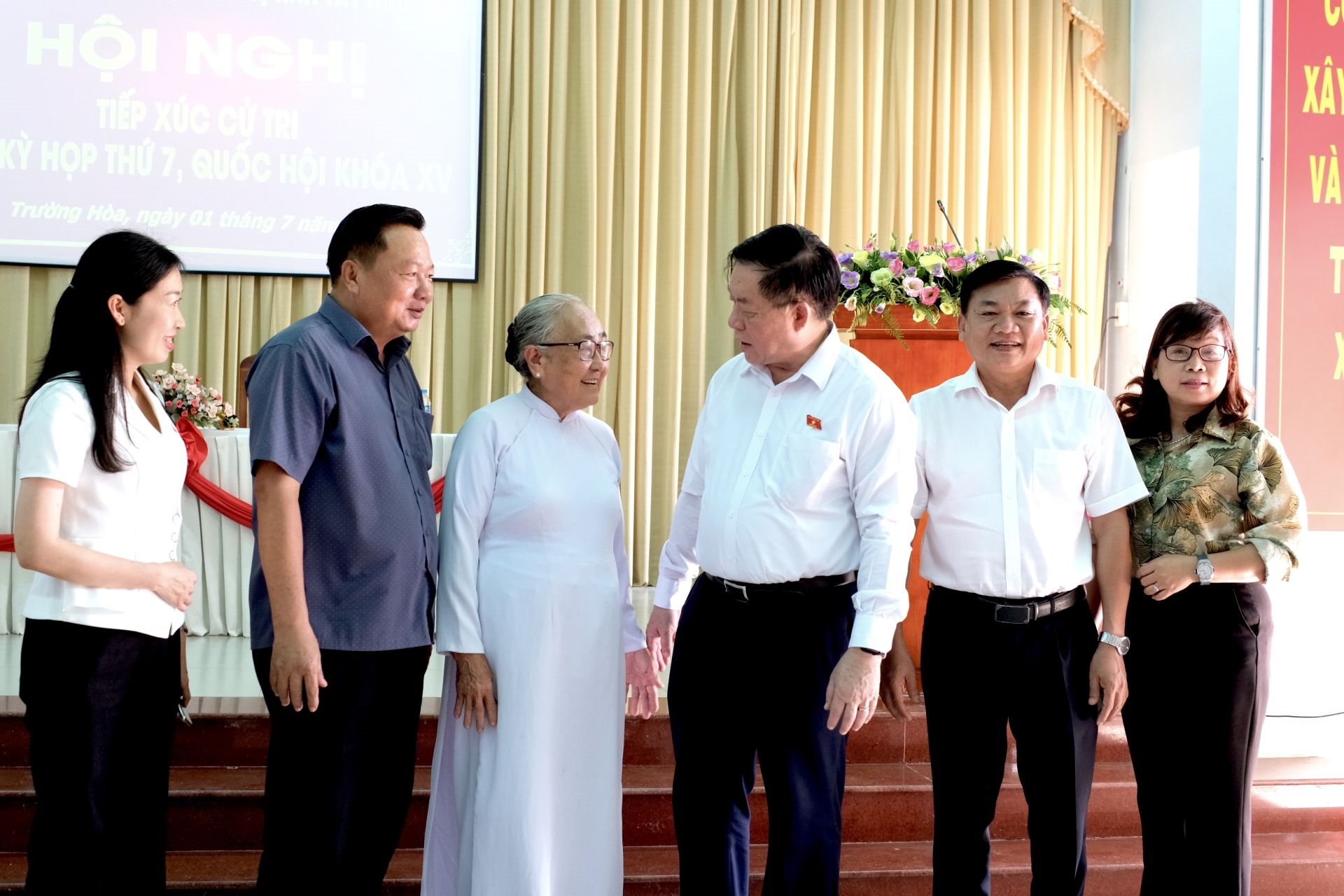 Đồng chí Nguyễn Trọng Nghĩa trao đổi với cử tri bên lề hội nghị.