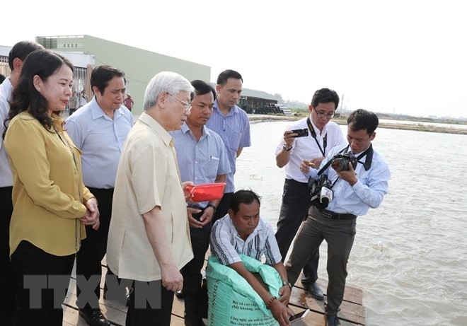 Tổng Bí thư Nguyễn Phú Trọng thăm vùng nuôi cá tra của Công ty TNHH phát triển Lộc Kim Chi. (Ảnh: TTXVN)