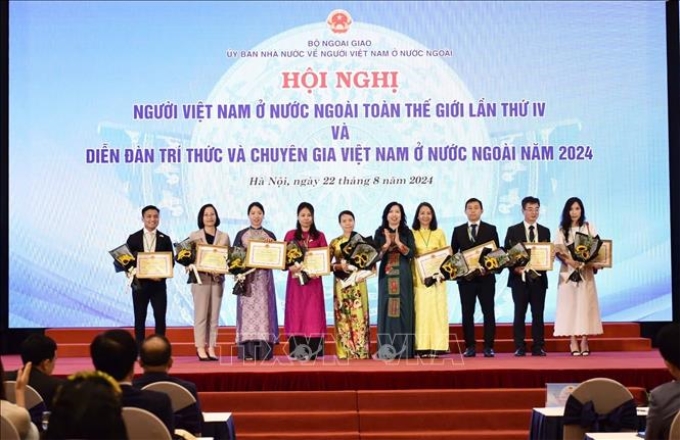 Thứ trưởng Bộ Ngoại giao Lê Thị Thu Hằng, Chủ nhiệm Ủy ban Nhà nước về người Việt Nam ở nước ngoài trao Giấy khen của Ủy ban tặng các tập thể và cá nhân kiều bào. (Ảnh: TTXVN)