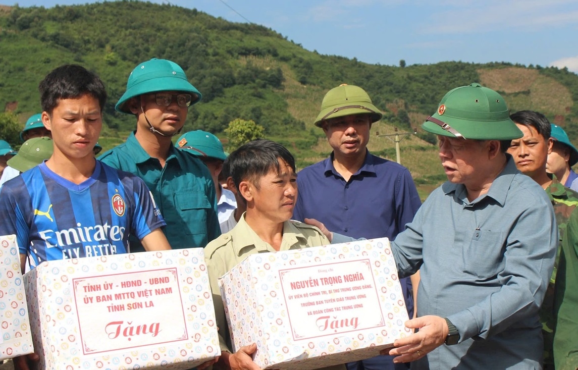 Đồng chí Nguyễn Trọng Nghĩa trao các phần quà hỗ trợ người dân ở bản Pú Dảnh, xã Ngọc Chiến.